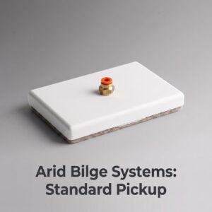 Close-up of a brass valve with an orange cap mounted on a white rectangular device, with a gray backdrop and partial text visible in the background (Standard Pickup).