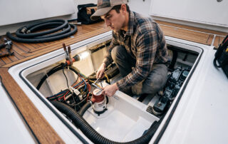 Man Working on Bilge Pump - The Real Cost of a Dry Bilge System vs. Adding More Bilge Pumps