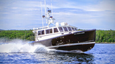 FV-TUNA.COM fishing boat underway, viewed from the bow quarter.