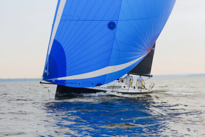 A sailing boat underway with a blue spinnaker.