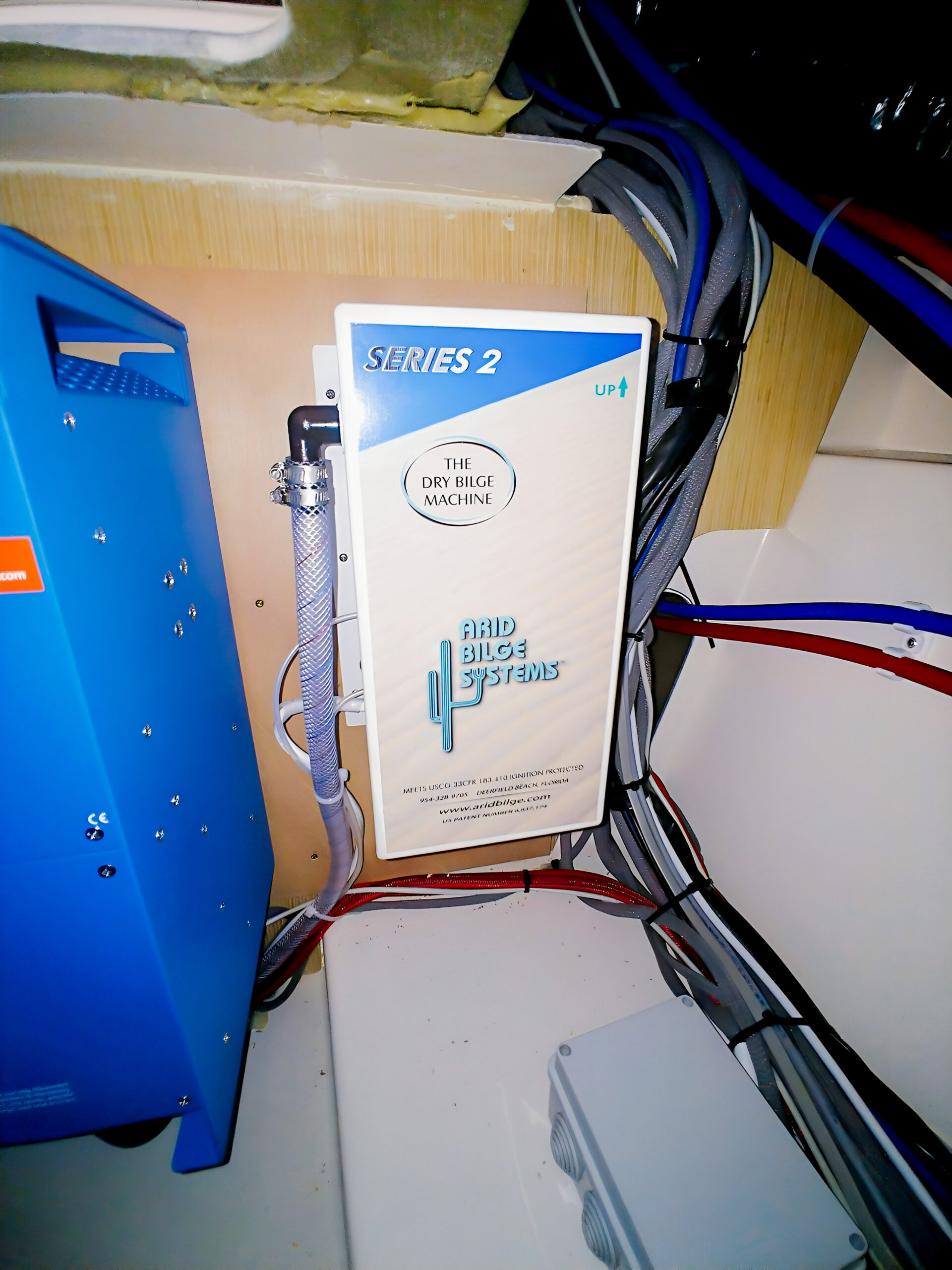 Greenline Yachts — Arid Series 2 installation - Arid Bilge Systems Arid Series 2 cabinet mounted beside a blue enclosure and cable runs in the Greenline installation feature.