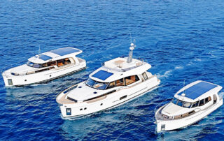 Three Greenline yachts underway together on blue water.