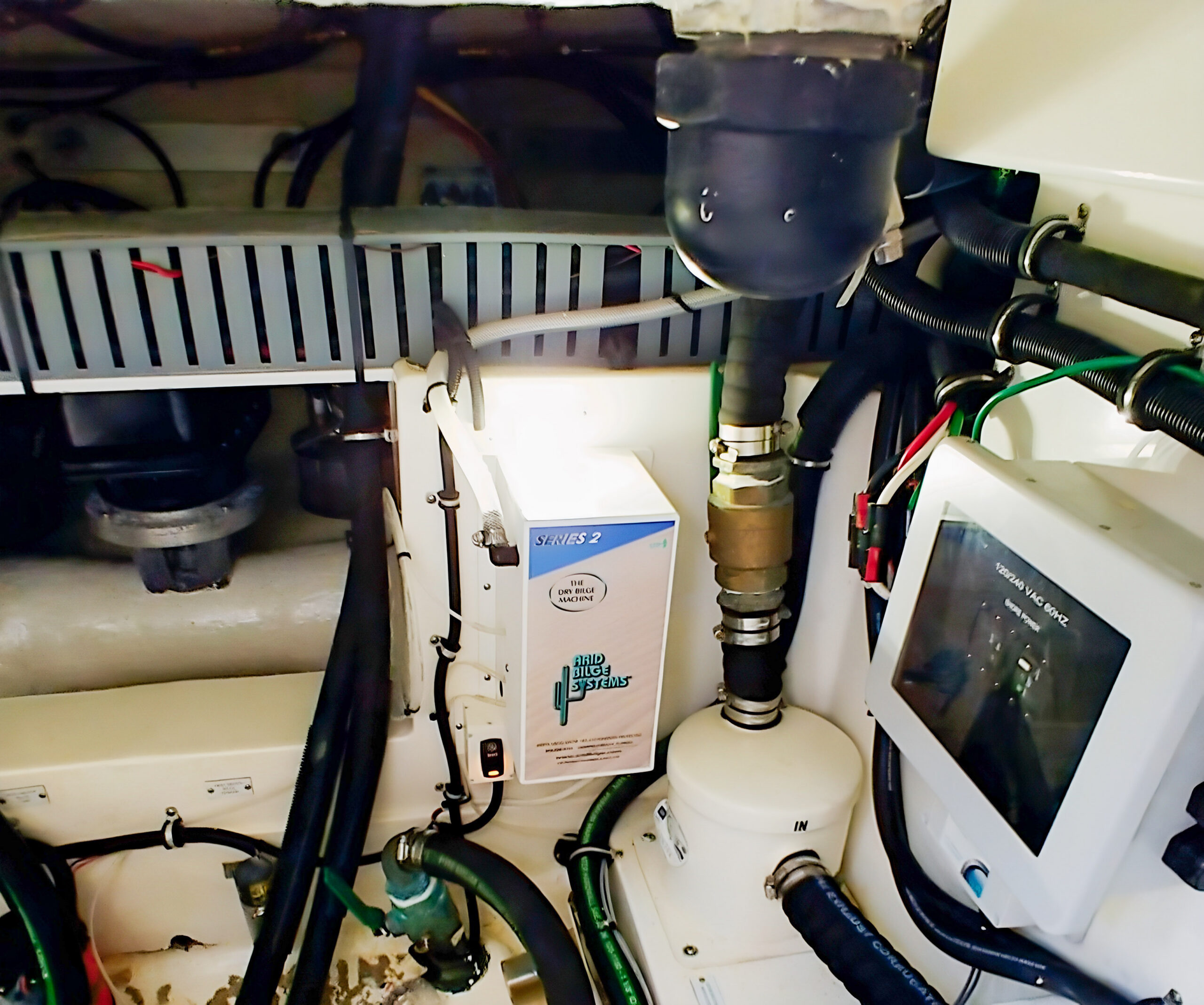 Arid Series 2 cabinet fitted beside hoses, wiring and other equipment in a HydraSports center console.