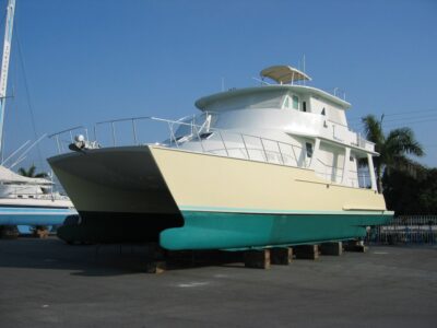 The twin hulls of a power catamaran in a boatyard.