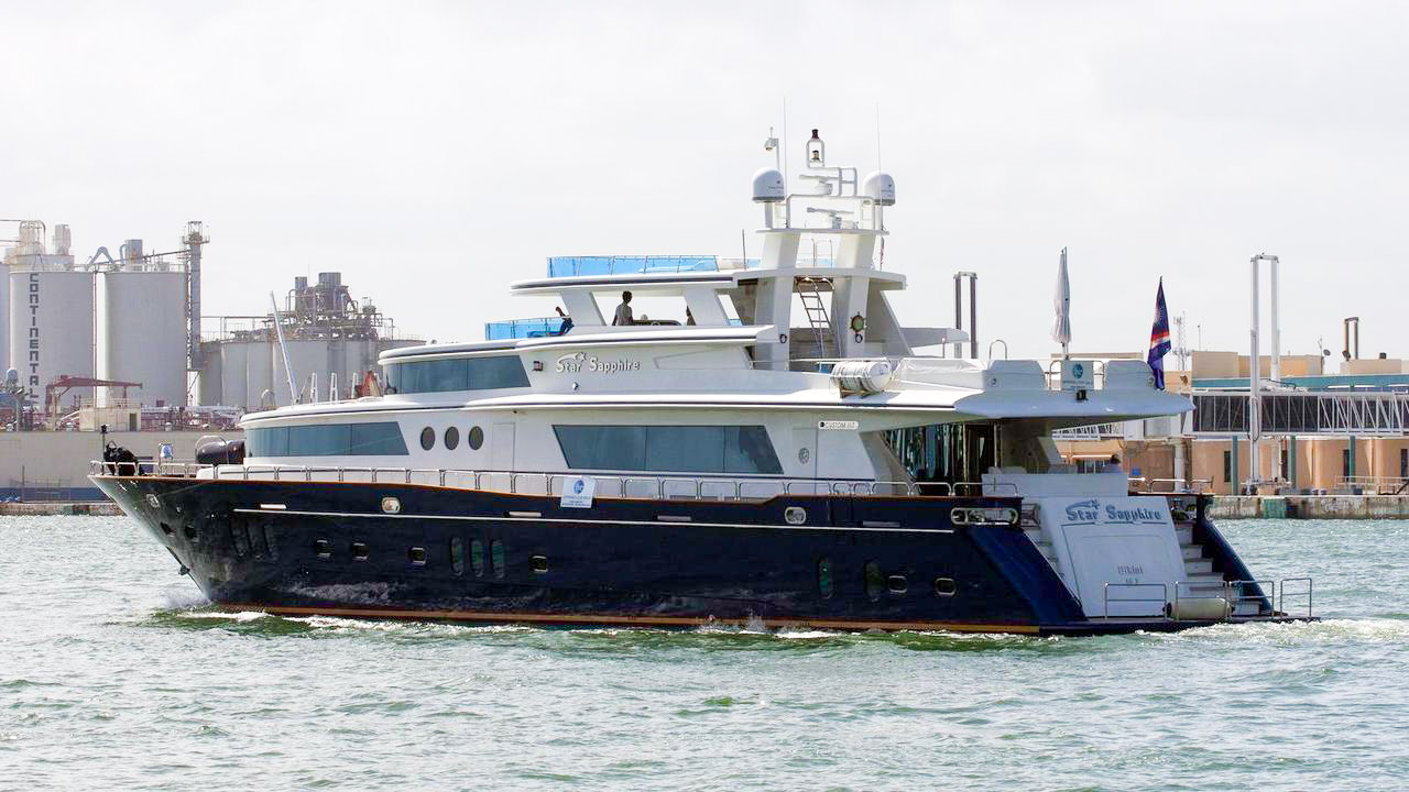 Star Sapphire, a blue-hulled yacht with a white superstructure, photographed from the side and stern in a harbor.